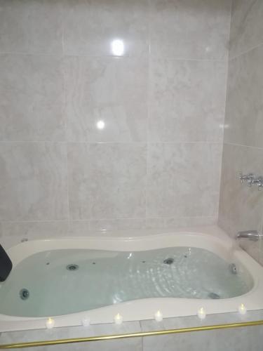 a white bath tub in a bathroom with a shower at Hotel Incas Suite, con Aguas Termomedicinales in Los Baños del Inca