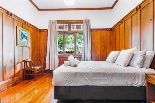 a bedroom with a large bed with a wooden wall at Character-Filled Home w Parking in Auckland