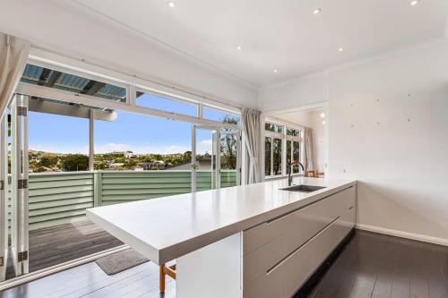 a kitchen with a white counter and a large window at Character-Filled Home w Parking in Auckland