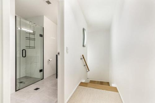 La salle de bains est pourvue d'une douche et d'une porte en verre. dans l'établissement Contemporary 1BR Queen Street Retreat, à Auckland