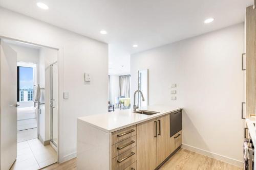 a kitchen with white walls and a sink and a window at Vibrant Minimalism - City Views in Auckland