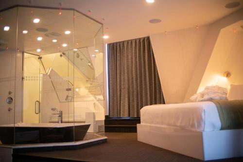 1 dormitorio con ducha, 1 cama y bañera en Hôtel Le Rivage, en Rosemère