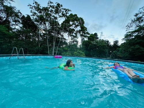 twee meisjes spelen in een zwembad bij Jonka House Private Jungle Oasis in Chachagua