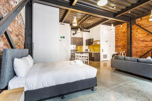 1 dormitorio con 1 cama y 1 sofá en una habitación en Modern Studio + Prime Location en Auckland