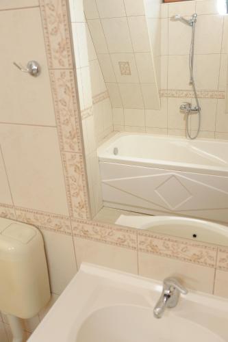 a bathroom with a tub and a toilet and a sink at Hotel Racic Self-Check In in Voyvodinovo