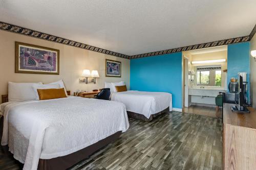 a hotel room with two beds and a flat screen tv at Knights Inn Madera in Madera