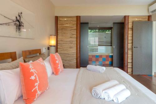a bedroom with a large white bed with towels on it at Les Villas du Lagon in Le François