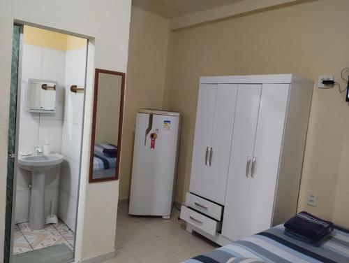 a small bathroom with a refrigerator and a sink at Residencial Andréa House in Manaus
