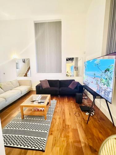 a living room with a couch and a large screen tv at Exclusive City Apartment - Very Spacious in Sheffield