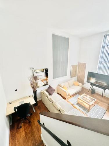 un soggiorno con un divano bianco e un pianoforte di Double height ceiling spacious city apartment a Sheffield
