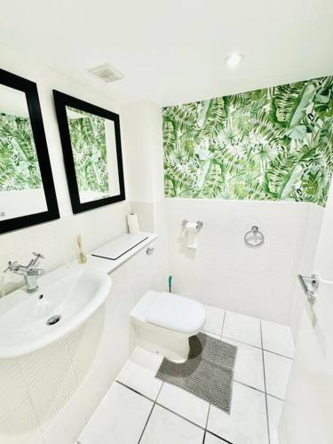 bagno bianco con servizi igienici e lavandino di Double height ceiling spacious city apartment a Sheffield