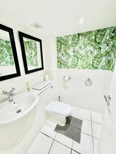 a white bathroom with a toilet and a sink at Exclusive City Apartment - Very Spacious in Sheffield