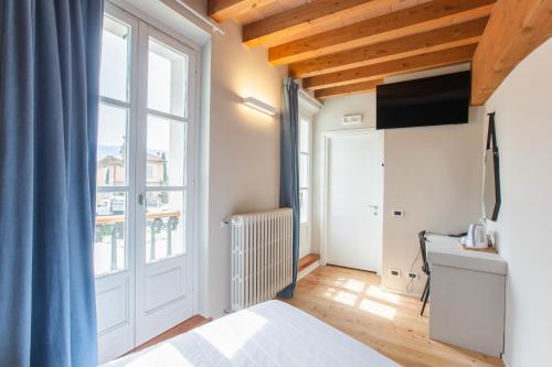 um quarto com uma cama e uma janela grande em Albergo Del Sole em Varenna