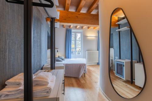 a mirror in a room with a bedroom at Albergo Del Sole in Varenna