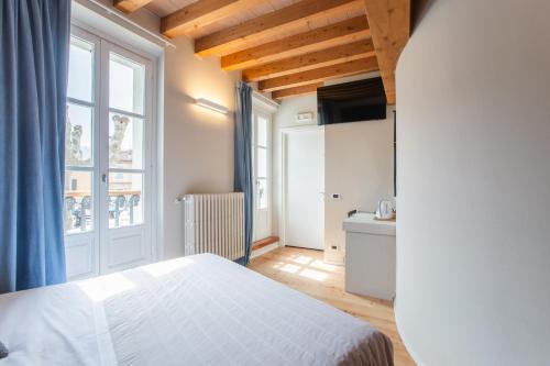 a bedroom with a white bed and a large window at Albergo Del Sole in Varenna