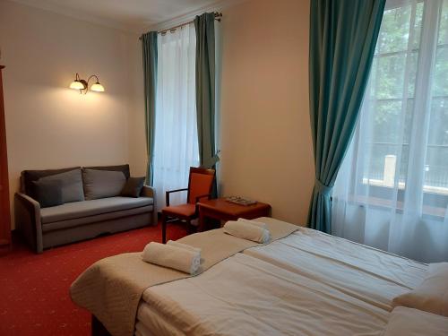 sypialnia z łóżkiem, kanapą i oknem w obiekcie Villa Toskana w Pogorzelicy