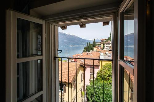 a window with a view of a city at Albergo Del Sole in Varenna