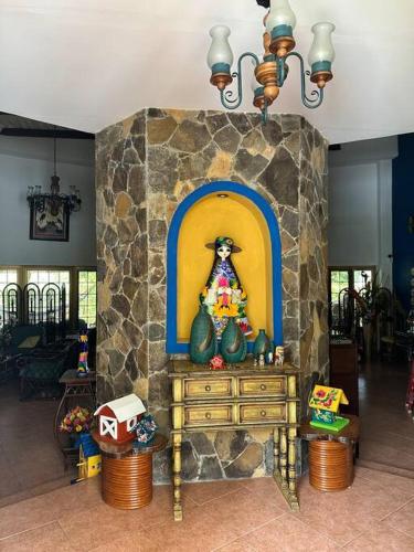 a living room with a stone fireplace with a dresser at Quinta Las Victorias in Valle de Anton