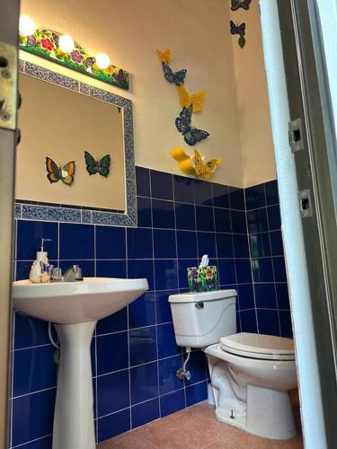 a blue tiled bathroom with a toilet and a sink at Quinta Las Victorias in Valle de Anton