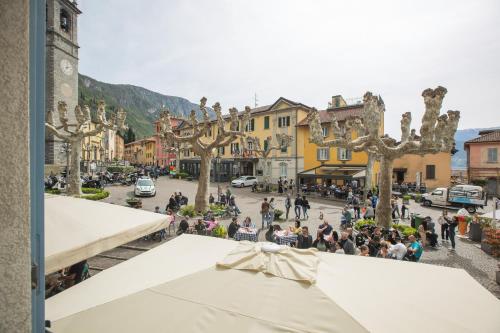 a crowd of people in a street with trees at Albergo Del Sole in Varenna