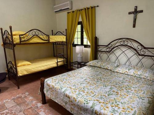 谷安東的住宿－Quinta Las Victorias，卧室设有两张双层床,墙上有十字架