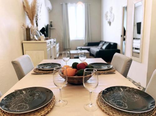 une table avec un bol de fruits et des verres à vin dans l'établissement Maison avec jardin, à Carcassonne