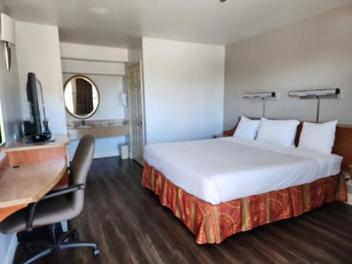 a hotel room with a large bed and a desk at Motel 6 Barstow, CA I15 and Lenwood Road in Barstow