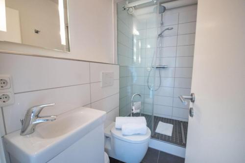 a bathroom with a toilet and a sink and a shower at Frische-Brise-11-06 in Cuxhaven