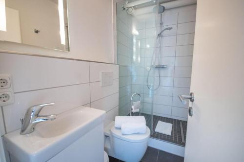 ein Bad mit einem WC, einem Waschbecken und einer Dusche in der Unterkunft Frische Brise 11.06 in Cuxhaven