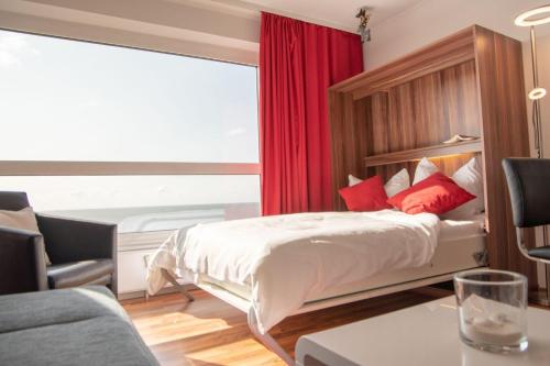 ein Schlafzimmer mit einem Bett mit einem roten Vorhang in der Unterkunft Frische Brise 11.06 in Cuxhaven