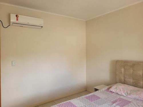 - une chambre avec un lit et un mur blanc dans l'établissement 1 dorm privativo casal, à Santa Rosa