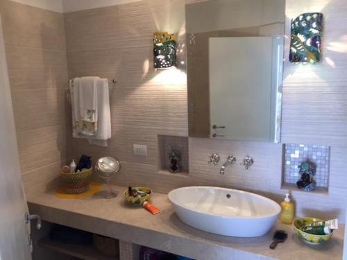 uma casa de banho com um grande lavatório branco e um espelho. em O’Sole em Capri