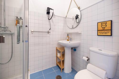 e bagno con servizi igienici, lavandino e doccia. di MUTE Hostel Milfontes a Vila Nova de Milfontes