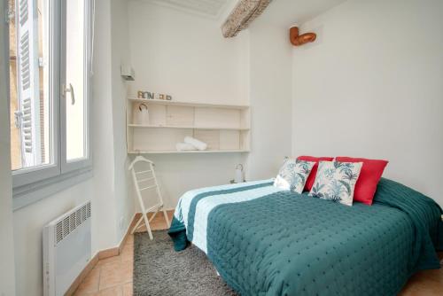 une petite chambre avec un lit et une fenêtre dans l'établissement L'atelier du Portail 9, à Saint-Tropez