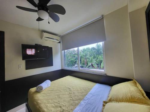 a bedroom with a bed and a window with a fan at R.7-7 Lindo estudio de 2 recámaras, zona turística in Panama City
