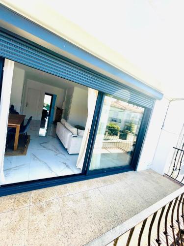 une grande fenêtre en verre d'une maison avec un canapé dans l'établissement Appartement 2 chambres 1 er etage, à Perpignan