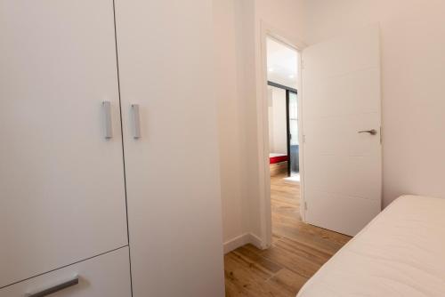 a white kitchen with white cabinets and a hallway at Villaverde 2 -apart in Madrid