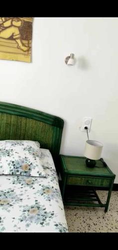 um quarto com uma cama e uma mesa com um candeeiro em Chez Nissa em Banyuls-sur-Mer