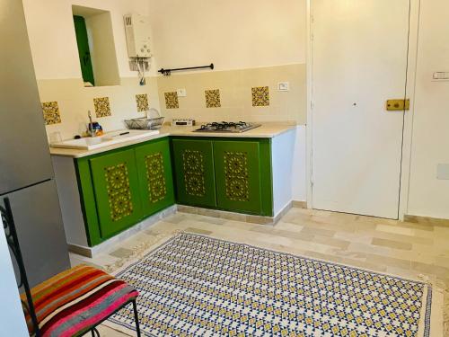a kitchen with green cabinets and a sink at DIAR HAROUN in Djerba