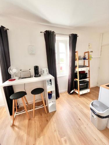 Cette petite chambre comprend un bureau et deux tabourets. dans l'établissement LE PTIT STEIR - CALME - WIFI - CENTRE VILLE - ENTREE AUTONOME, à Quimper