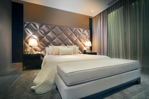 a bedroom with a large bed with a large headboard at Villa Balimu Seminyak in Seminyak