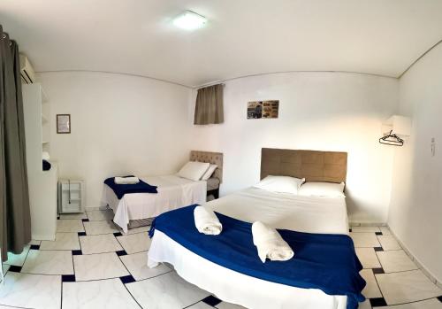 a bedroom with two beds and a tiled floor at Guest House Mel & Mar in Penha