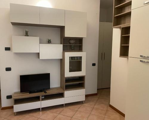 sala de estar con TV y armarios blancos en Shalu Home, en Verona