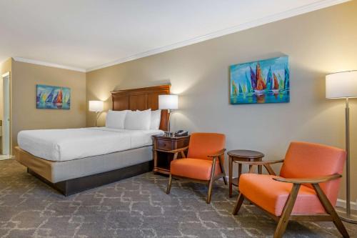 サンティーにあるBest Western PLUS Santee Innのベッド1台と椅子2脚が備わるホテルルームです。