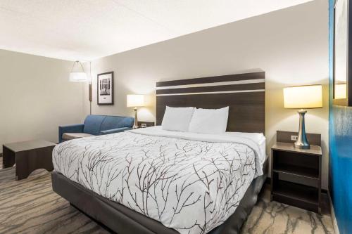 a hotel room with a bed and a blue chair at Best Western Plus Knoxville Cedar Bluff in Knoxville