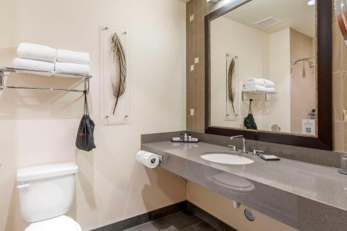 a bathroom with a sink and a toilet and a mirror at Best Western Premier Boulder Falls Inn in Lebanon