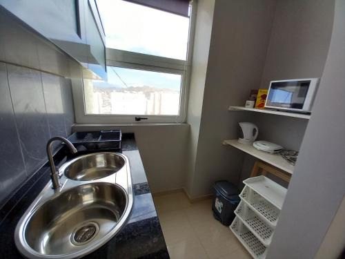 baño con lavabo y ventana en SILVAs Apartment en Mindelo