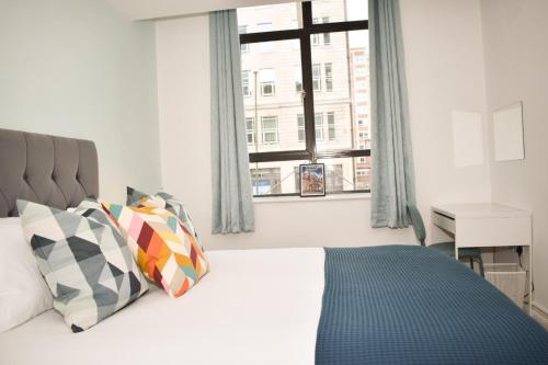 una camera da letto con un grande letto e una finestra di Vibrant Serviced Apartment In Central Birmingham a Birmingham