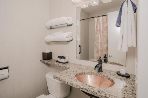 a bathroom with a sink and a toilet and a mirror at Pantai Inn in San Diego