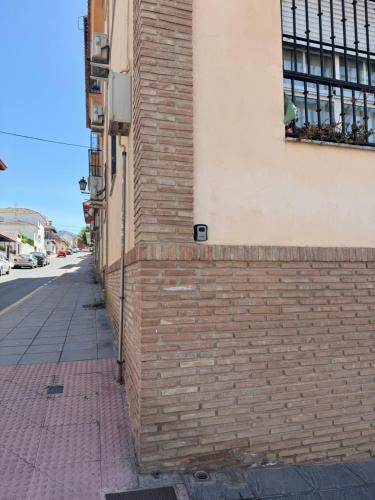 una pared de ladrillo en el lateral de un edificio en Bonito piso a solo 15 minutos de Granada en La Zubia
